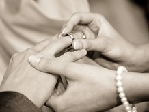 Ring being placed on a finger at a wedding